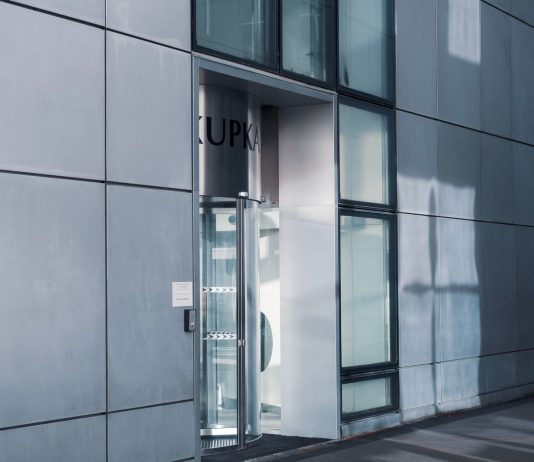 BREAKING: NJ Opens Free Office Space in Jersey City to Lure Foreign Firms Sleek modern architecture featuring a glass entrance with reflective facade, showcasing contemporary design.