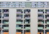 Multicolored urban apartment building with balconies and windows, showcasing city living.