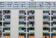 Multicolored urban apartment building with balconies and windows, showcasing city living.