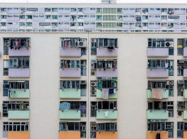 Multicolored urban apartment building with balconies and windows, showcasing city living.