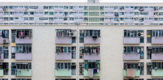 Multicolored urban apartment building with balconies and windows, showcasing city living.
