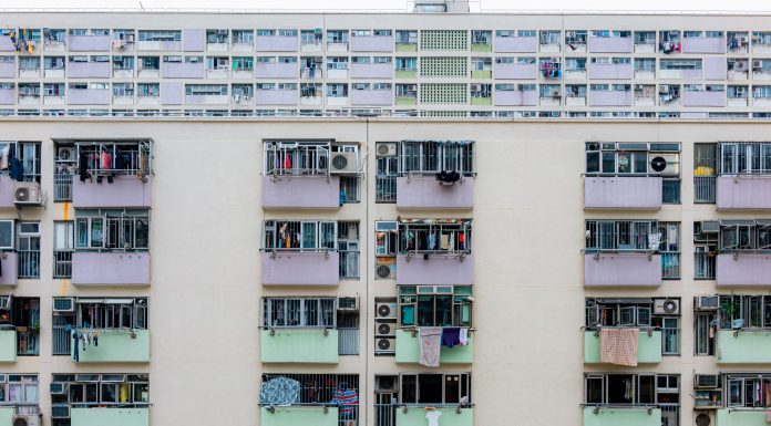 Multicolored urban apartment building with balconies and windows, showcasing city living.