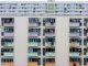 Multicolored urban apartment building with balconies and windows, showcasing city living.