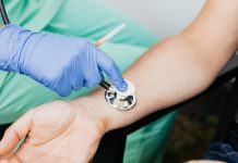 BREAKING: RWJBarnabas Donates $1.3M to Jersey City Nonprofits Healthcare professional using a stethoscope on patient's wrist during a medical exam.