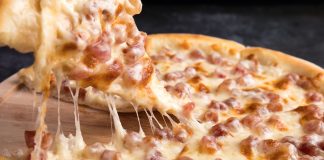 Close-up of a delicious pepperoni pizza slice with gooey mozzarella cheese.