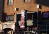 BREAKING: Two New Food Concepts Coming to Newark Avenue in Jersey City Neon signage of Dallas BBQ Restaurant illuminated in an urban environment at sunset.