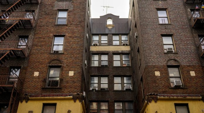 BREAKING: West New York Short-Term Rents Soar 1,500% for World Cup Low-angle view of urban brick apartment buildings with fire escapes, embodying classic city architecture.