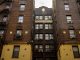 Low-angle view of urban brick apartment buildings with fire escapes, embodying classic city architecture.