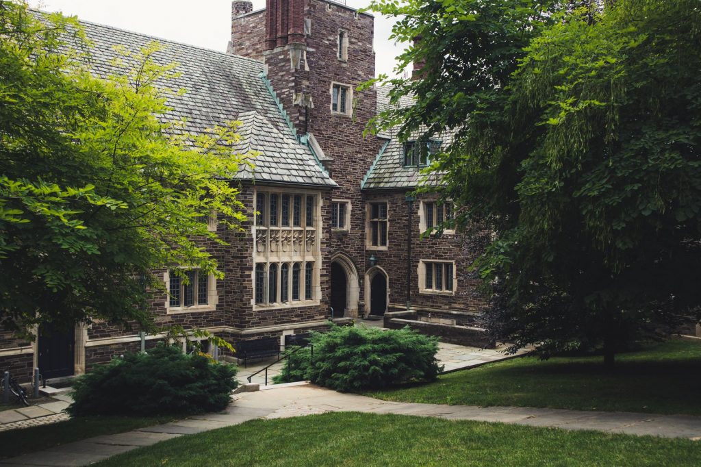 Elegant Gothic architecture of Princeton University surrounded by lush greenery on a summer day.
