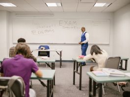 A college educator proctoring an exam, enforcing no cheating rules.
