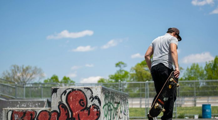 Man with skateboard at urban skatepark, Clifton NJ. Vibrant graffiti art.