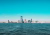 Panoramic view of Manhattan skyline with modern skyscrapers under a clear blue sky.