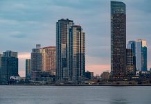 Twilight view of the iconic New York City skyline with skyscrapers and tranquil waters.