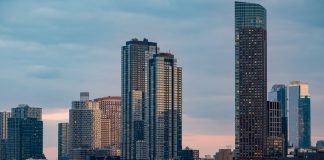 Twilight view of the iconic New York City skyline with skyscrapers and tranquil waters.