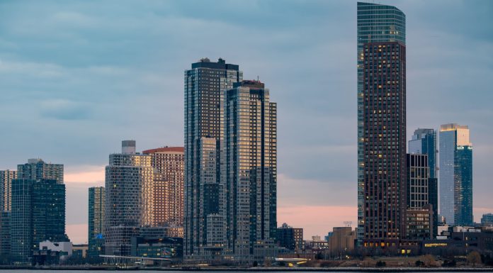Twilight view of the iconic New York City skyline with skyscrapers and tranquil waters.