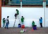 Downtown Church Members Trade Pews for Paintbrushes to Help Neighbors Group of artists painting a mural on a public wall outdoors using ladders and stools.