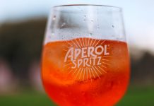 Elizabeth’s New Italian Spot Has an Aperol Spritz Vending Machine Refreshing Aperol Spritz cocktail on a sunny day with a blurred outdoor background.