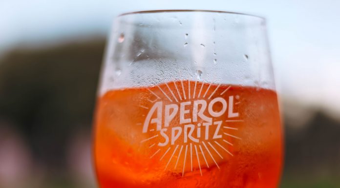 Elizabeth’s New Italian Spot Has an Aperol Spritz Vending Machine Refreshing Aperol Spritz cocktail on a sunny day with a blurred outdoor background.