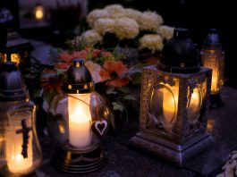 Lanterns with candles illuminate a cemetery on All Saints' Day.