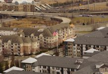 Aerial view of urban residential apartments featuring an American flag, depicting city life.
