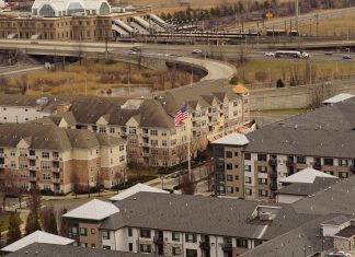 ¿Es Seguro Vivir en Union City? Guía Completa de Seguridad 2026 Aerial view of urban residential apartments featuring an American flag, depicting city life.