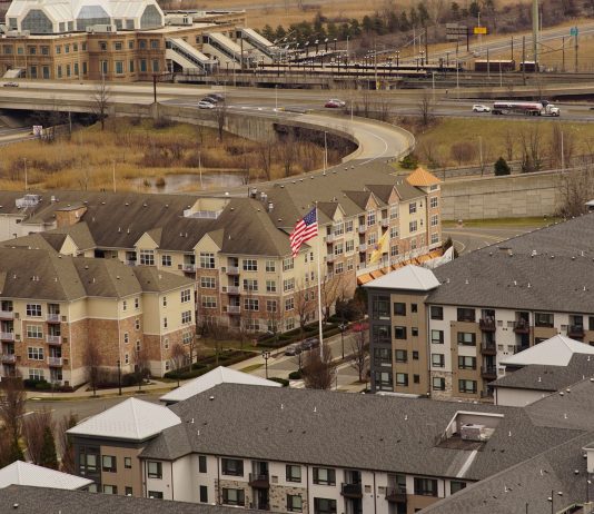 Aerial view of urban residential apartments featuring an American flag, depicting city life.