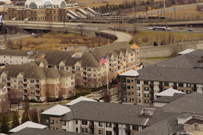Aerial view of urban residential apartments featuring an American flag, depicting city life.