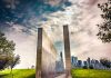 Stunning reflection memorial with New York City skyline in the background under a dynamic sky.