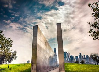 Stunning reflection memorial with New York City skyline in the background under a dynamic sky.