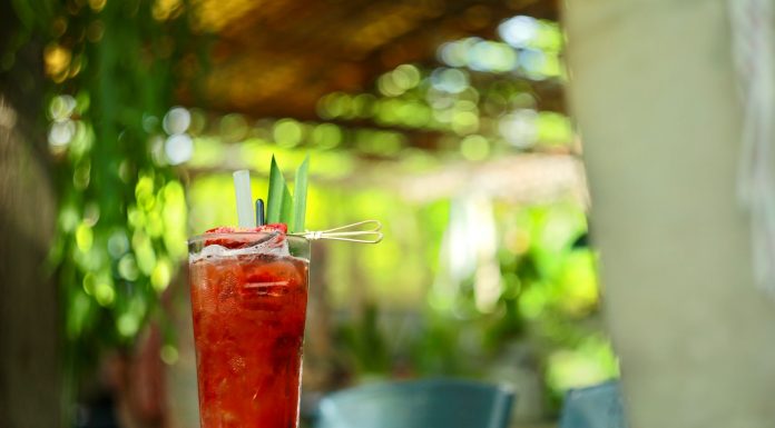 Guide to Top Brunch Spots in Hoboken by Category A vibrant strawberry cocktail with pineapple garnish on an outdoor table in sunny garden.