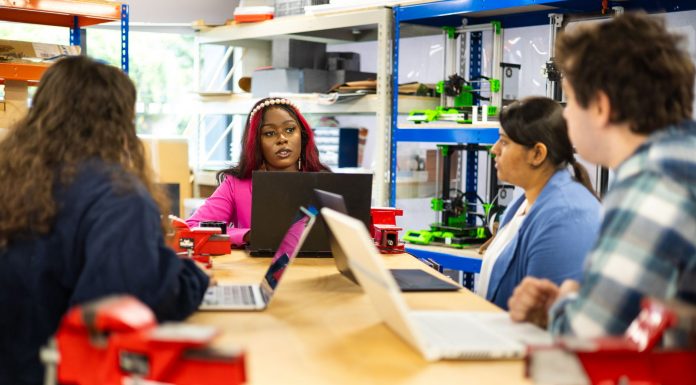 HCCC Forms AI Council to Guide Students, Faculty Into New Tech Era Diverse group of students engaged in a collaborative technical class discussion in a workshop setting.