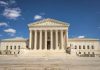 The majestic facade of the United States Supreme Court under a clear blue sky.