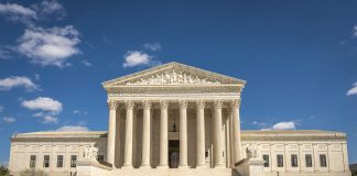 The majestic facade of the United States Supreme Court under a clear blue sky.
