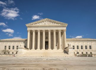 The majestic facade of the United States Supreme Court under a clear blue sky.