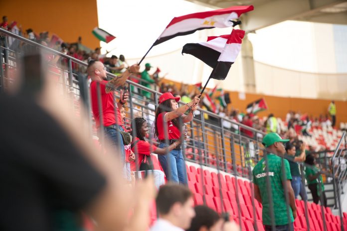 hoboken-offers-free-world-cup-tickets-to-local-you Soccer fans in the stadium wave Egyptian flags, showing their support during a lively sports match.