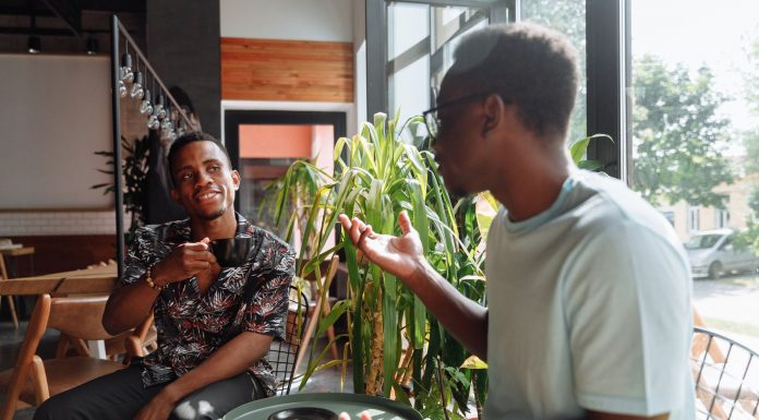 Hoboken’s Third Spaces Feel Lonely? Here’s the Real Solution Two friends having a lively conversation over coffee in a cozy coffee shop setting.