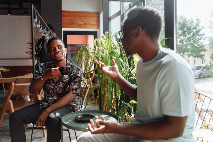 hoboken-s-third-spaces-feel-lonely-here-s-the-real Two friends having a lively conversation over coffee in a cozy coffee shop setting.