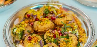 Tempting plate of crunchy Pani Puri topped with colorful garnishes.