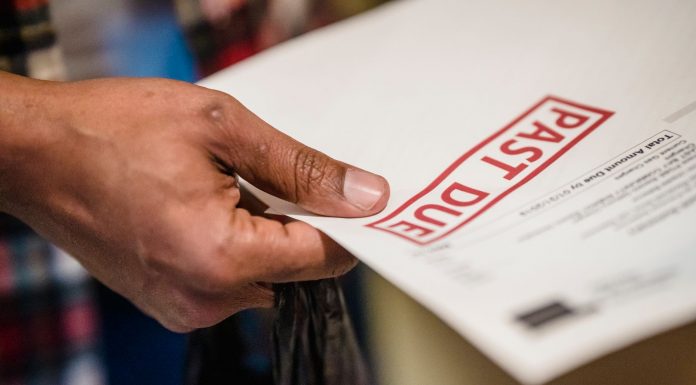 Interim report says Jersey City owes $109M in unpaid bills from Fulop administration A close-up of a hand holding a document with a 'Past Due' stamp, highlighting financial urgency.