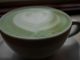 Close-up of a frothy matcha latte with heart latte art in a ceramic cup, warm and inviting.