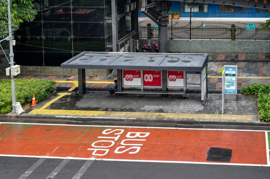 Bus stop in Jakarta, Indonesia with empty seating area and modern urban surroundings.