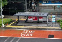 Bus stop in Jakarta, Indonesia with empty seating area and modern urban surroundings.