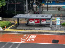 Bus stop in Jakarta, Indonesia with empty seating area and modern urban surroundings.