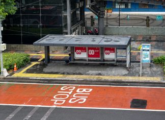 Bus stop in Jakarta, Indonesia with empty seating area and modern urban surroundings.