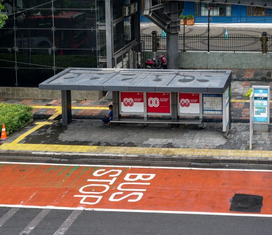 Bus stop in Jakarta, Indonesia with empty seating area and modern urban surroundings.