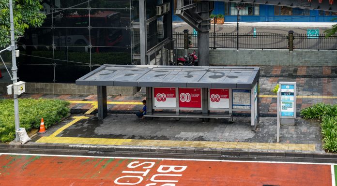 Bus stop in Jakarta, Indonesia with empty seating area and modern urban surroundings.