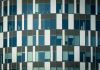 Close-up of a modern office building facade with geometric patterns and glass windows.