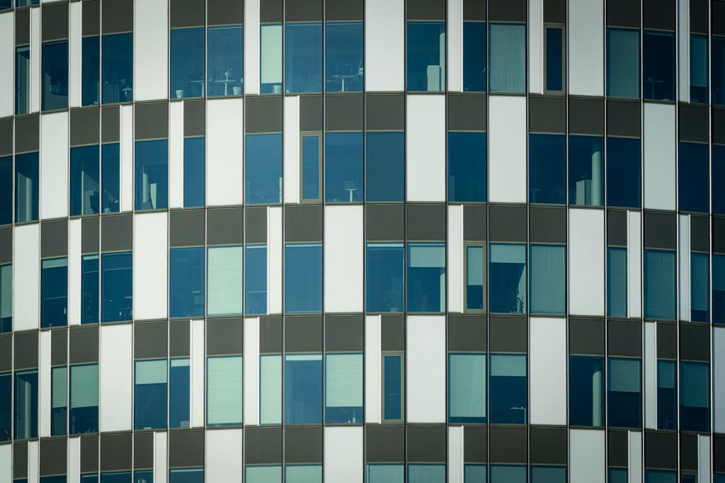 Close-up of a modern office building facade with geometric patterns and glass windows.