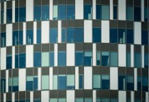 Close-up of a modern office building facade with geometric patterns and glass windows.