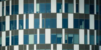 Close-up of a modern office building facade with geometric patterns and glass windows.